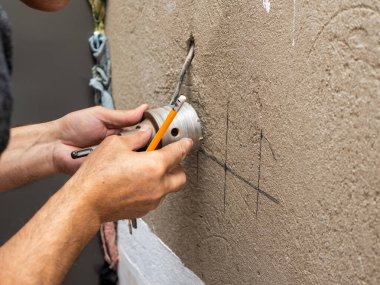 Soket kutusu duvarda, soket kutusu bina duvarında. Profesyonel işçinin elektrik tesisatı, soket matkabı