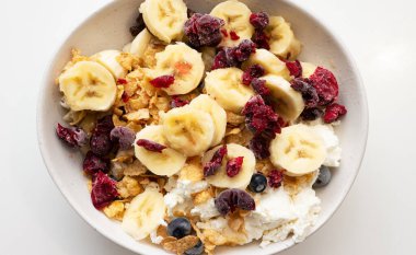 Böğürtlenli muz, süzme peynir ve mutfakta bir tabakta kuru üzüm. Muz, böğürtlen ve donmuş kirazla iştah açıcı.
