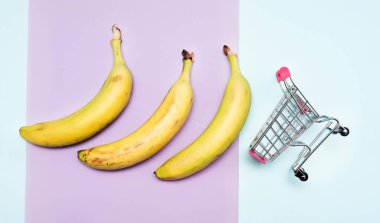 Arka planda süpermarket arabasında muz. Market sepetinde yasaklı yaratıcı bir resim..