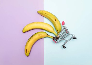 Arka planda süpermarket arabasında muz. Market sepetinde yasaklı yaratıcı bir resim..