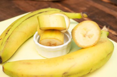 Mutfakta dilimlenmiş muz, bıçakla kesilmiş tahta..