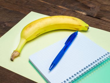Not defterli muz ve mesaj için boş sayfa. Meyveli notlar. Not defteri ve muzlu kalem..