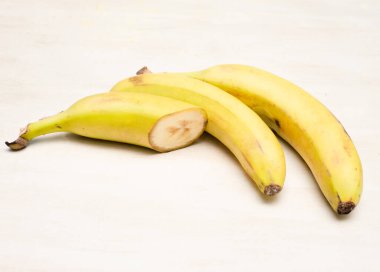 Sarı arka planda iki parçaya ayrılmış olgun muz.