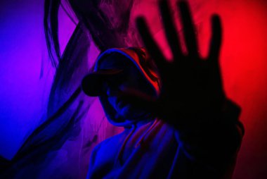 Genç bir adam el hareketini durdurur, jesti durdurur, müzik kulaklıklarıyla karanlıkta bir adam