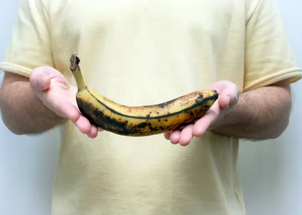 Banana in the peel of a man\'s hand