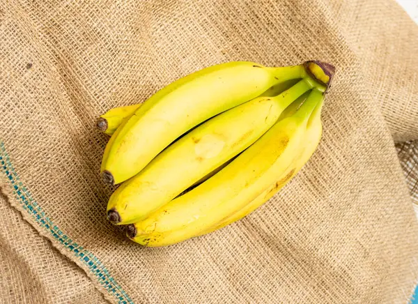 Ripe bananas on an old bag. Beautiful yellow bananas top view