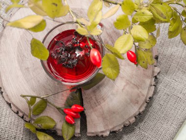 Terapötik gül çayı, şeffaf bir fincanda kırmızı çay, kırmızı gül tentürü. Homeopati, naturopatik çay. meyve suyu