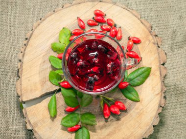 Terapötik gül çayı, şeffaf bir fincanda kırmızı çay, kırmızı gül tentürü. Homeopati, naturopatik çay. meyve suyu