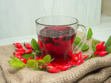 Terapötik gül çayı, şeffaf bir fincanda kırmızı çay, kırmızı gül tentürü. Homeopati, naturopatik çay. meyve suyu