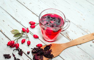 Terapötik gül çayı, şeffaf bir fincanda kırmızı çay, sağlık için bitkisel tortulu gül üzümü. Homeopati, naturopatik çay. meyve suyu