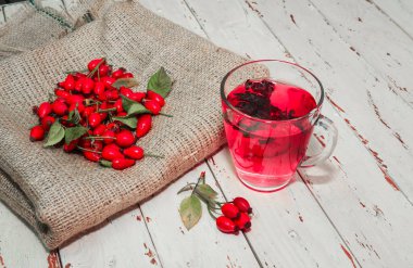 Terapötik gül çayı, şeffaf bir fincanda kırmızı çay, sağlık için bitkisel tortulu gül üzümü. Homeopati, naturopatik çay. meyve suyu