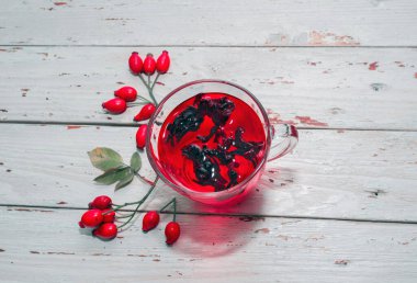 Terapötik gül çayı, şeffaf bir fincanda kırmızı çay, sağlık için bitkisel tortulu gül üzümü. Homeopati, naturopatik çay. meyve suyu