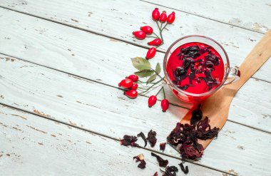 Terapötik gül çayı, şeffaf bir fincanda kırmızı çay, sağlık için bitkisel tortulu gül üzümü. Homeopati, naturopatik çay. meyve suyu