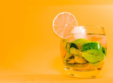 Bardakta pipetle Mojito. Portakal dilimli nane likörü. Şeffaf bardakta soda. Alkolik Apperol. Buzlu doğal meyve suyu..