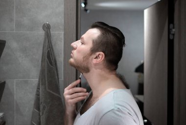 Bıçakla tıraş olur, sakalını banyoda tıraş eder.