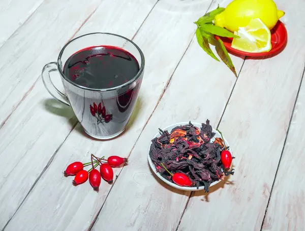 Red berry tea, tea from red rosehip berries. Naturopathy, medical syrup or tincture. Rosehip medicinal in a drink. Homeopathy