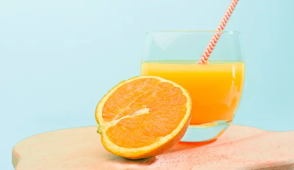 Orange lemonade with a straw in a glass. Summer orange drink with orange slice. Soda in a transparent glass. Apperol alcoholic drink. Natural juice with ice. Multivitamin freshly squeezed.