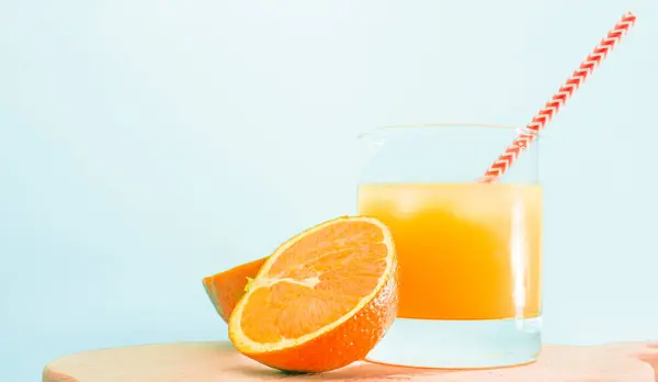 Orange lemonade with a straw in a glass. Summer orange drink with orange slice. Soda in a transparent glass. Apperol alcoholic drink. Natural juice with ice. Multivitamin freshly squeezed.