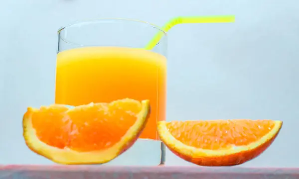 Juice with a straw in a glass. Summer orange drink with orange slices. Soda in a transparent glass. Apperol alcoholic drink. Natural juice with ice. Multivitamin fresh squeezed.