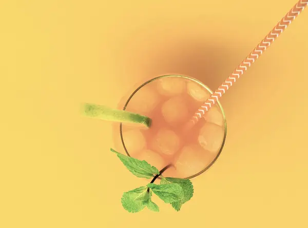 Lemonade with a straw in a glass. Summer drink orange with mint, with ice. Soda in a transparent glass. Apperol alcoholic drink, Apperol in a transparent glass with mint and lime