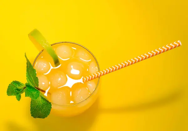 Lemonade with a straw in a glass. Summer drink orange with mint with ice. Soda in a transparent glass. Apperol alcoholic drink, Apperol with mint and lime top view