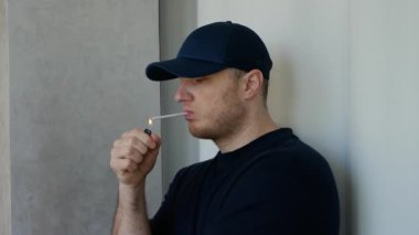 Genç bir adam sigara yakıyor. Çakmaklı hafif sigara. Tütün içiyorum.