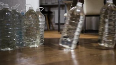 Bir adam acil durum suyunu plastik şişelerde biriktirir ve saklar. Savaş sırasında içme suyu kıtlığı vardı. Elinde bir şişe su olan bir adam..