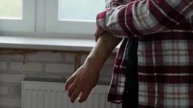 Yaşlı bir adam kolunu kaşır. Alerji yaşlı bir insanda görülen bir cilt hastalığıdır. Egzaması olan bir emekli. Sivrisinek ısırığı deriyi tırmalıyor.