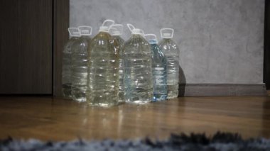 Acil durum suyunu plastik şişelerde depolamak. Savaş sırasında içme suyu kıtlığı vardı. Elinde bir şişe su olan bir adam.