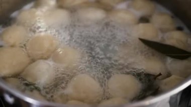 Hamur köfteleri tavada pişirilir. Tavada kaynamış hamur köftesi. Mutfakta ağır çekimde yemek pişirmek..