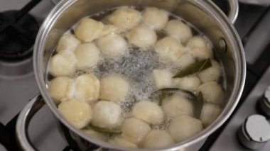 Hamur köfteleri tavada pişirilir. Tavada kaynamış hamur köftesi. Mutfakta ağır çekimde yemek pişirmek.