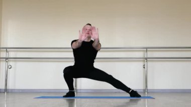 Spor minderinde yoga. Bale eğitimi, genç bir adam plastik koreografi yapıyor. Klasik dans ısınması.
