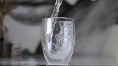 Yavaş çekim kamerasıyla bardağa su dökmek. Şeffaf bardakta içmek için temiz su.