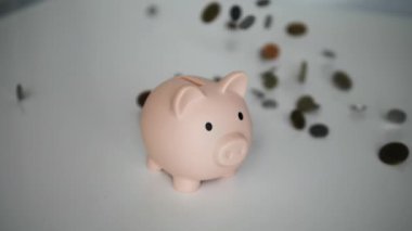 Beyaz arka planda bozuk paralar olan kumbaralar. Para biriktiriyorum. Para sikkeleri yavaş çekimde düşüyor. Mali kriz kavramı