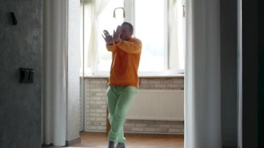 Genç bir adam evde dans ediyor. İnsanların aktif dans yaşam tarzı.