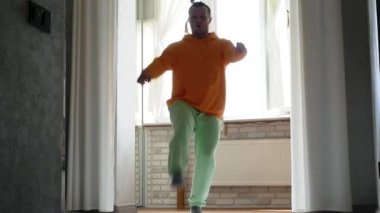 Genç bir adam evde dans ediyor. İnsanların aktif dans yaşam tarzı.