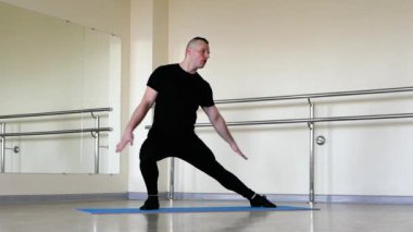 Spor salonunda ısınma dansı yap, genç bir adam antrenman sırasında gerinir. Caz ayakkabılı ve klasik üniformalı bir adam.