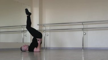 Atletik ve esnek plastik dansçılar ısınıyor. Bir jimnastikçi vücut dalgası yapar. Profesyonel yoga sporcusu spor salonunda ısınıyor..