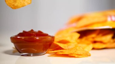 Patates cipsini ağır çekimde kırmızı sosa batırmak. Soslu patates kızartması ye.