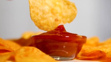  Patates cipsini yavaş çekimde kırmızı sosa batırmak. Tatlı soslu lezzetli cipsler ye. Fast food konsepti