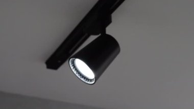 Tavanda benekli lamba izi var. Ağır çekimde kay. Elektrik avizesi, modern siyah.