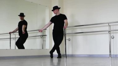 Caz dansı ya da bastonlu Caberet provası. Gangster şapkalı genç bir adam parmaklarını şaklatıyor. Yaratıcı dans blues adamı, siyah elbiseli.