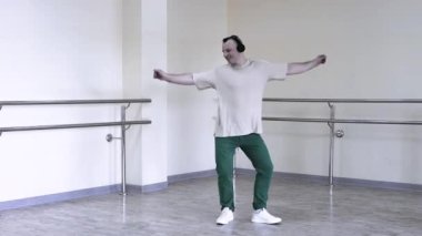 Müzik kulaklığı takan bir adam yaratıcı bir dans yapar, el hareketleri karizmatiktir. Genç bir adam en sevdiği müziği kulaklıkla bir duvarın arkasında dinler..