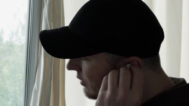 Kulaklıkla konuşan, kablosuz kulaklıkla arayan, kulaklıkla müzik dinleyen bir adam.