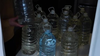 Cannes 'da acil içme suyu. Bir insan plastik şişelerde içme suyu saklar.