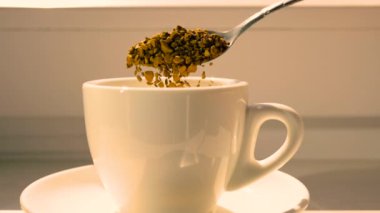 Kahve hazırlığı bir fincanda. Yavaş çekimde hazır kahveyi fincana boşalt. Kahve parçacıkları