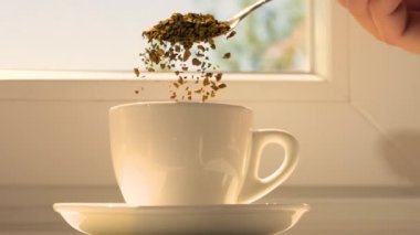 Kahve hazırlığı bir fincanda. Yavaş çekimde hazır kahveyi fincana boşalt. Kahve parçacıkları.