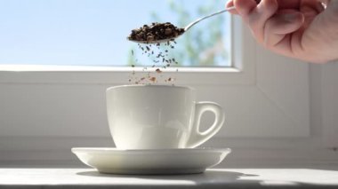 Yavaş çekimde hazır kahveyi kahve bardağına dök. Hazır kahve çekirdeklerini kaşıkla serp.