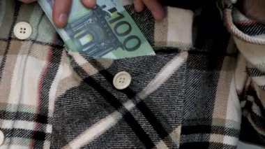 Banknotları giysi cebine koy. Bir adam gömleğinin cebinde nakit taşır. Kıyafetlerin içinde para saklıyorsun. Yavaş çekim.