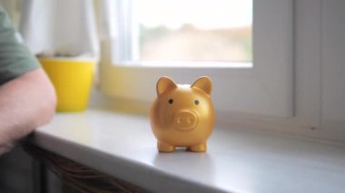Yaşlı bir adamın eli kumbaraya bozuk para atıyor ve bankadan tasarruf ediyor. Yavaş çekim